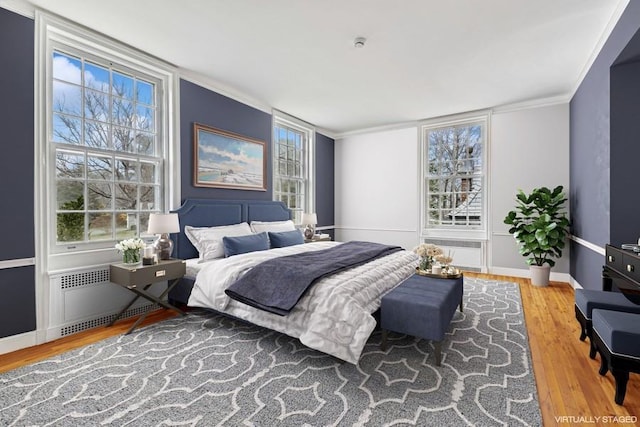 bedroom featuring multiple windows, wood finished floors, and crown molding