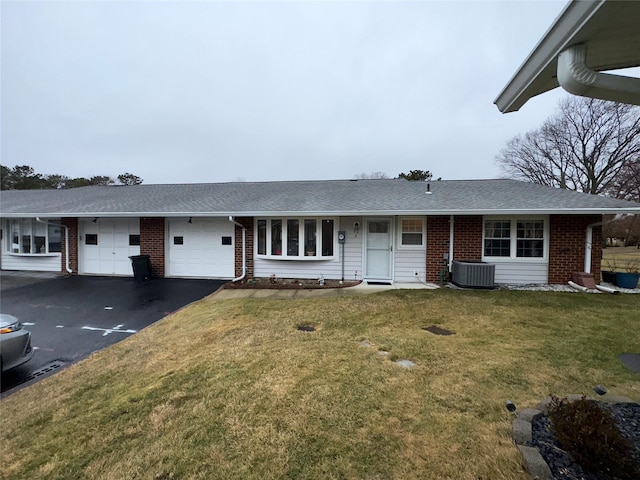 single story home with central AC, a garage, and a front lawn