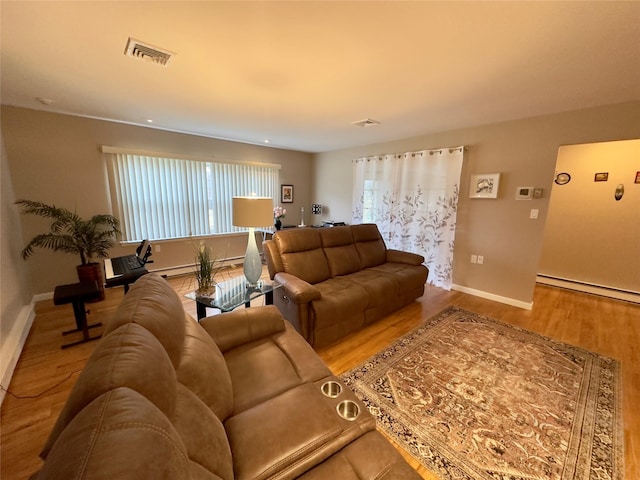 living room with hardwood / wood-style flooring and a baseboard heating unit