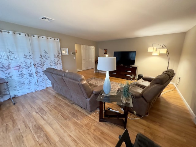 living room with a baseboard radiator and light wood-type flooring