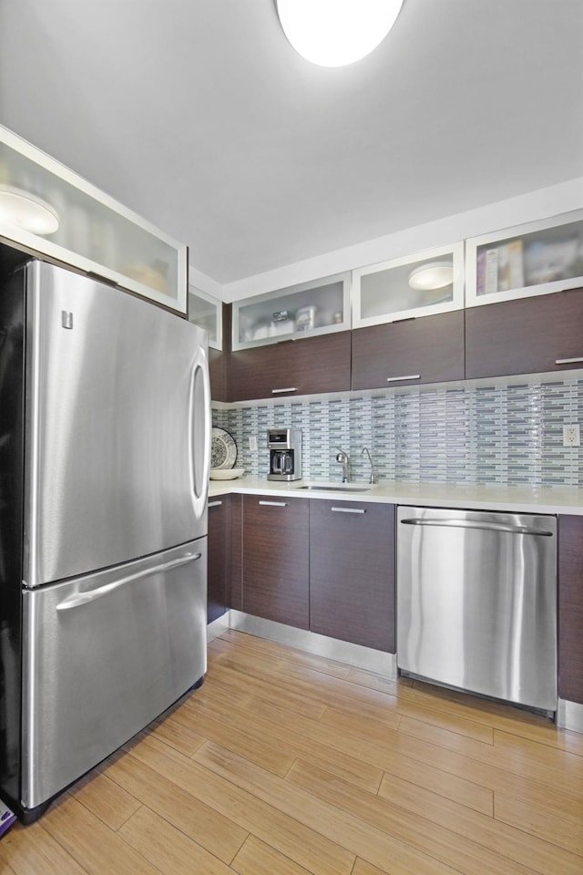 kitchen featuring sink, dark brown cabinets, stainless steel appliances, and light hardwood / wood-style floors