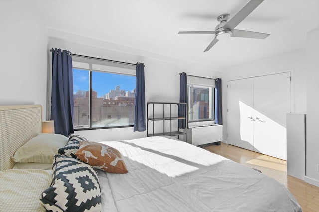 bedroom featuring ceiling fan, light hardwood / wood-style floors, and a closet