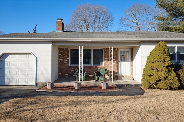 ranch-style home featuring a porch, a garage, and a front lawn