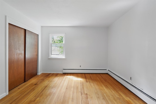 49 Pine Ave, Ossining, NY 10562 - unfurnished bedroom featuring a baseboard radiator, hardwood / wood-style flooring, a baseboard heating unit, a closet, and baseboards