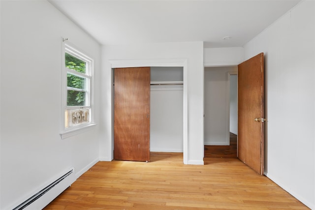 49 Pine Ave, Ossining, NY 10562 - unfurnished bedroom featuring baseboard heating, light wood-style floors, a closet, and baseboards