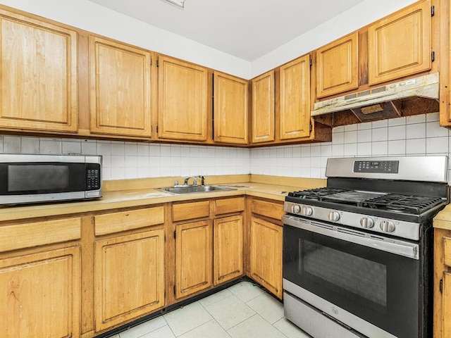 kitchen featuring sink, backsplash, light tile patterned flooring, and appliances with stainless steel finishes