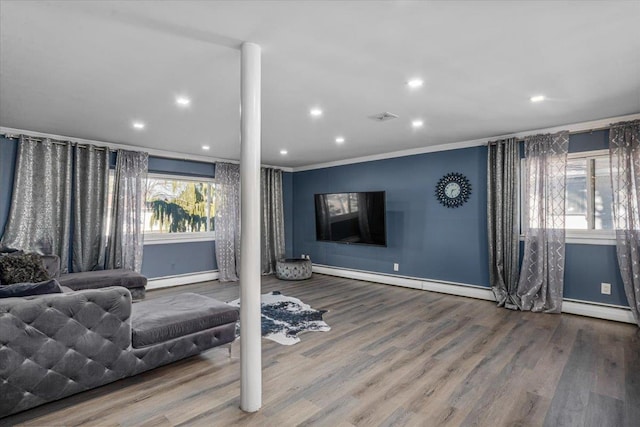 workout area with crown molding, a baseboard radiator, and wood-type flooring