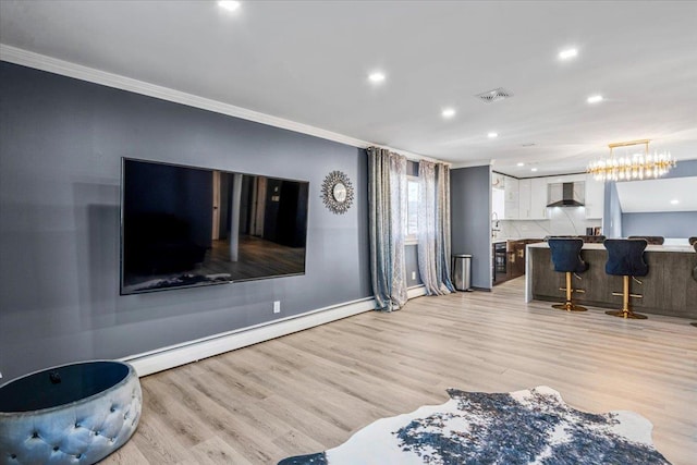 living room featuring crown molding, baseboard heating, and light hardwood / wood-style flooring