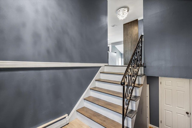 stairs with hardwood / wood-style flooring and a baseboard radiator