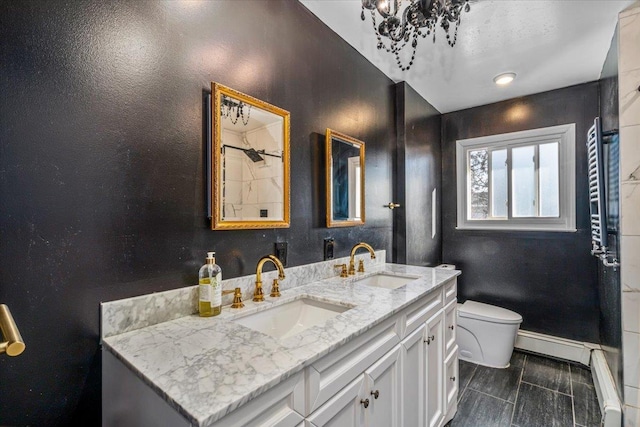 bathroom featuring vanity, a baseboard heating unit, and toilet