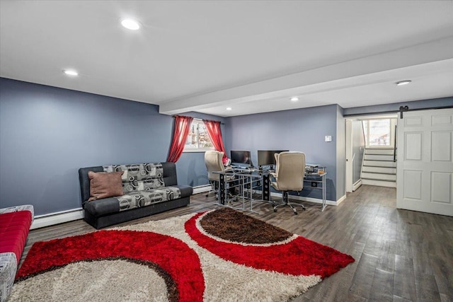 living room with a barn door, dark hardwood / wood-style floors, and baseboard heating