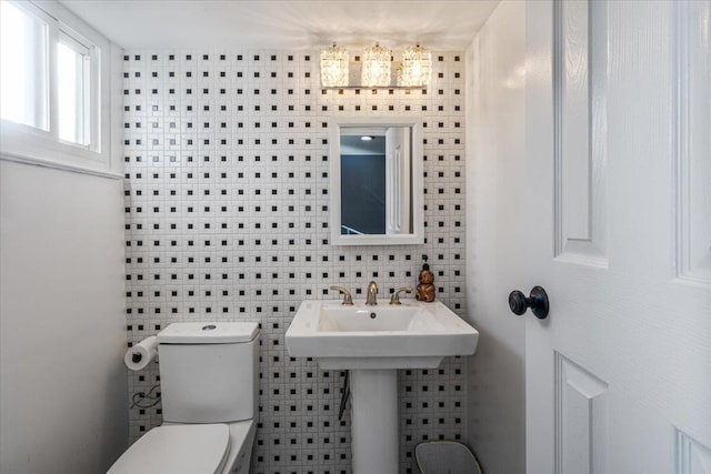 bathroom with sink, tile walls, and toilet