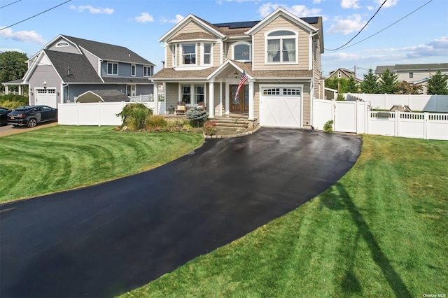 view of front of property with a garage, a front lawn, covered porch, and solar panels