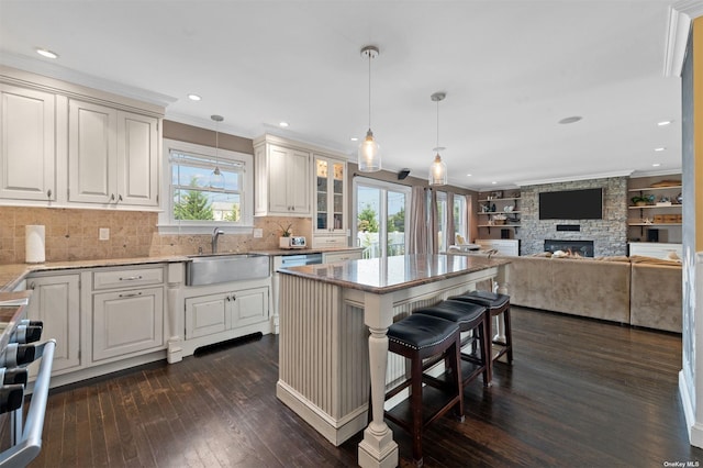 kitchen featuring sink, stove, a kitchen island, a kitchen bar, and decorative light fixtures