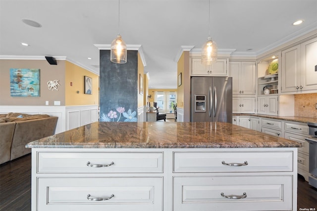 kitchen featuring pendant lighting, stainless steel fridge with ice dispenser, dark stone counters, and a kitchen island