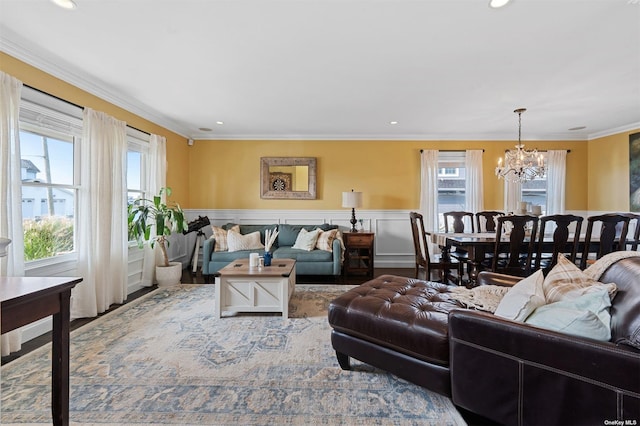 living room with a wealth of natural light, ornamental molding, and a chandelier