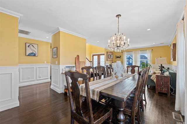 dining space with crown molding, dark wood-type flooring, and a chandelier