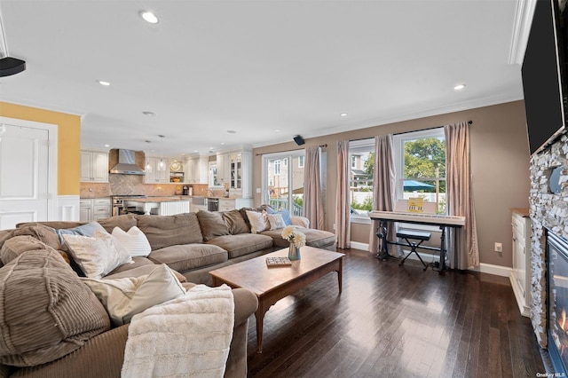 living room featuring crown molding, a stone fireplace, and dark hardwood / wood-style floors