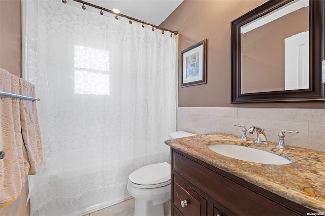 bathroom with tile patterned floors, vanity, toilet, and tile walls