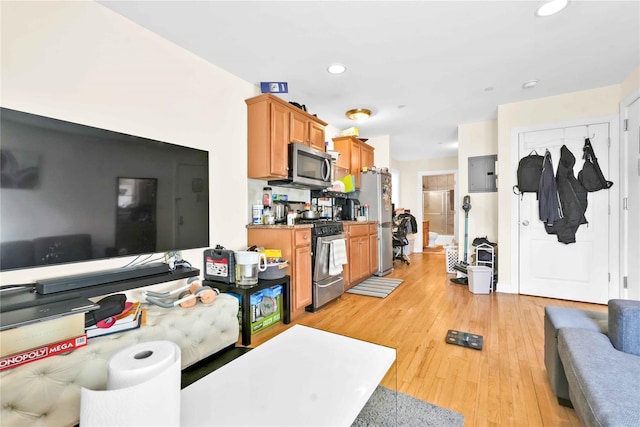 kitchen with stainless steel appliances, electric panel, and light hardwood / wood-style flooring