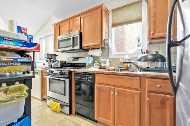 kitchen with light tile patterned floors, vaulted ceiling, stainless steel appliances, and sink