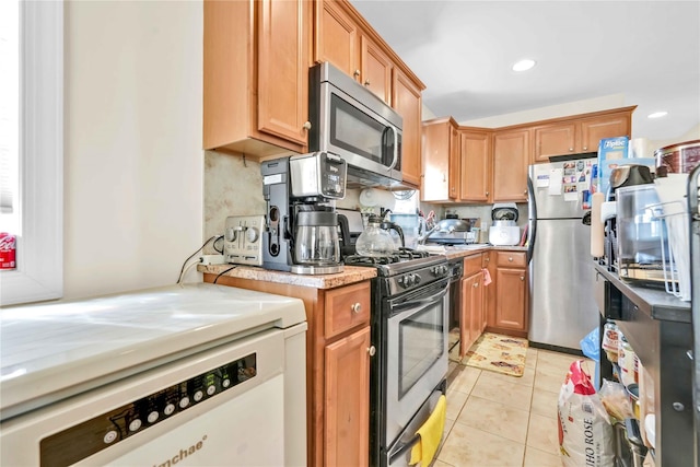 kitchen with light tile patterned flooring and appliances with stainless steel finishes