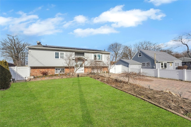 view of front facade featuring a front yard and solar panels