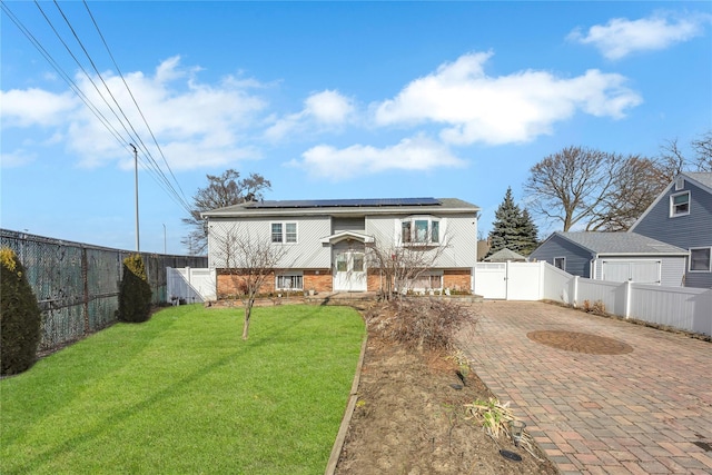 view of front of home with a front yard and solar panels