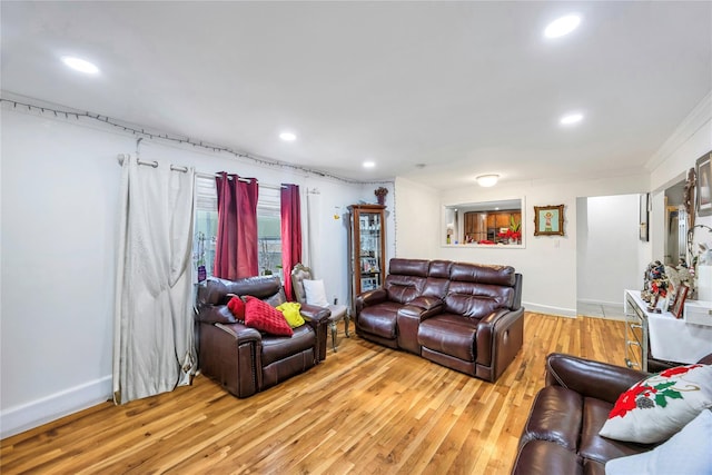 living room with ornamental molding and light hardwood / wood-style floors