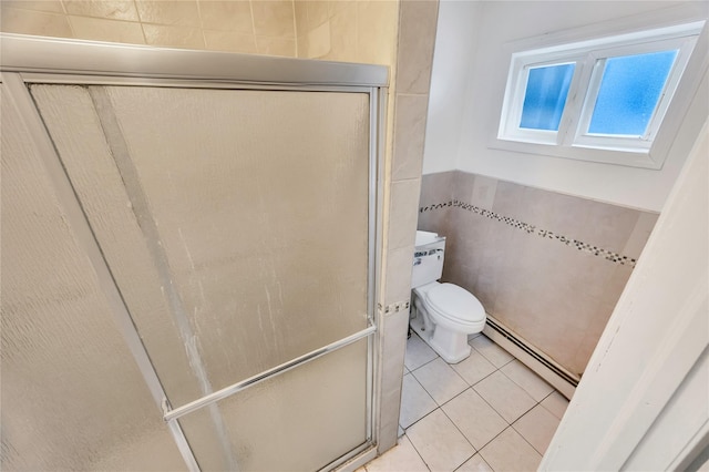 bathroom featuring tile walls, a baseboard heating unit, toilet, a shower with door, and tile patterned floors