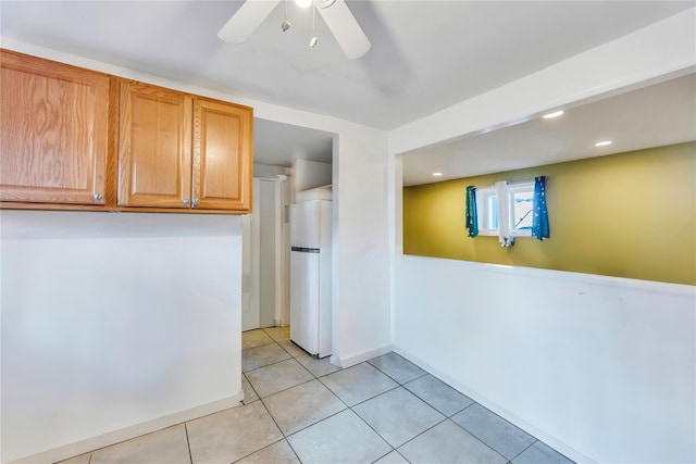 interior space featuring white refrigerator, ceiling fan, and light tile patterned floors