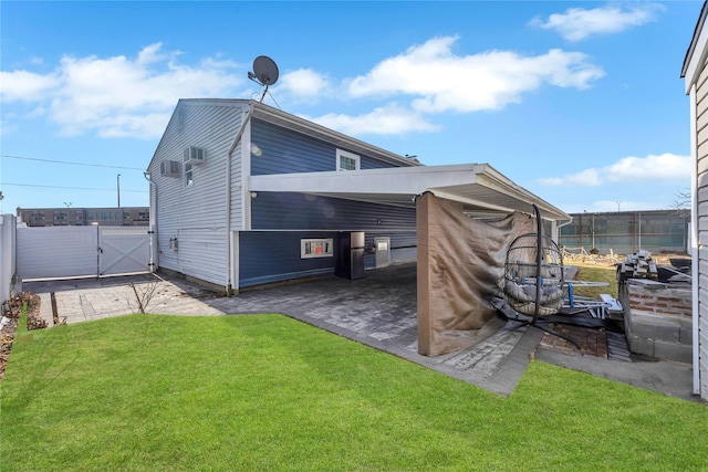 back of property with a carport and a lawn