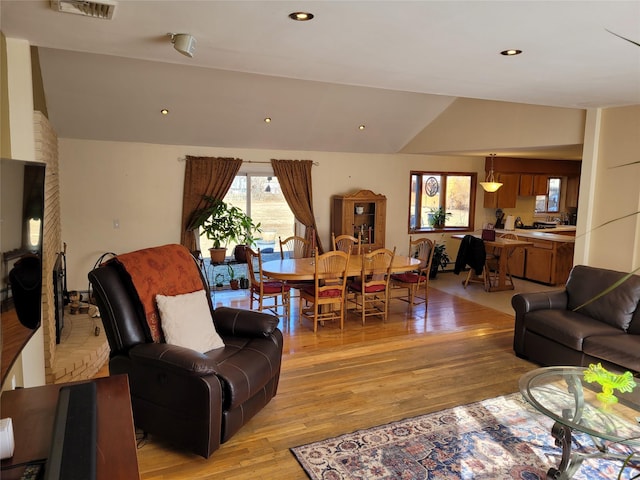 living room with lofted ceiling and light hardwood / wood-style floors