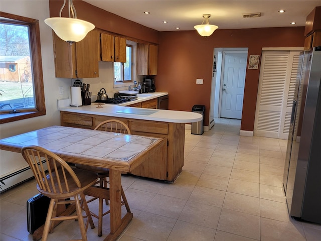 kitchen featuring hanging light fixtures, light tile patterned floors, black appliances, and kitchen peninsula