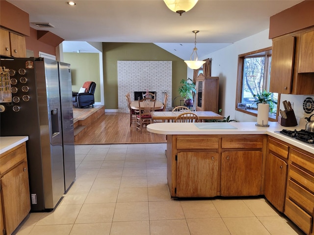 kitchen featuring stainless steel refrigerator with ice dispenser, sink, hanging light fixtures, and light tile patterned floors