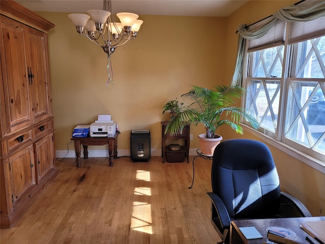 office area featuring an inviting chandelier, a healthy amount of sunlight, and light wood-type flooring