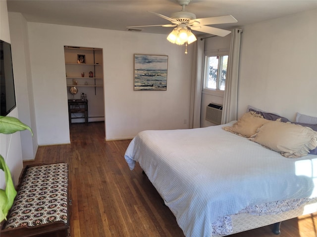 bedroom featuring dark wood-type flooring, a walk in closet, ceiling fan, and cooling unit