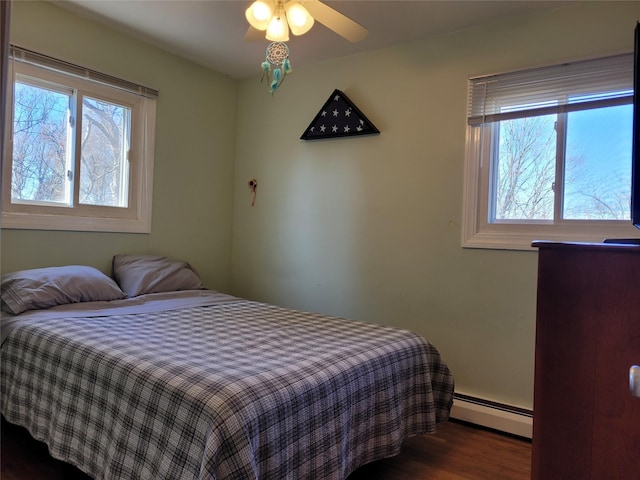 bedroom featuring a baseboard radiator, dark hardwood / wood-style floors, and ceiling fan