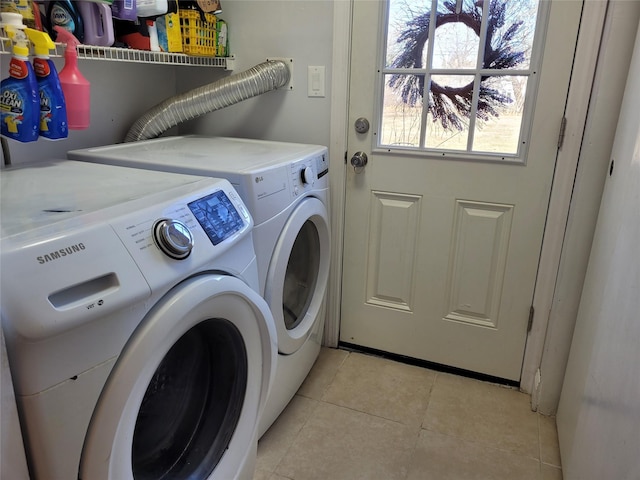 laundry area with light tile patterned floors and washing machine and clothes dryer