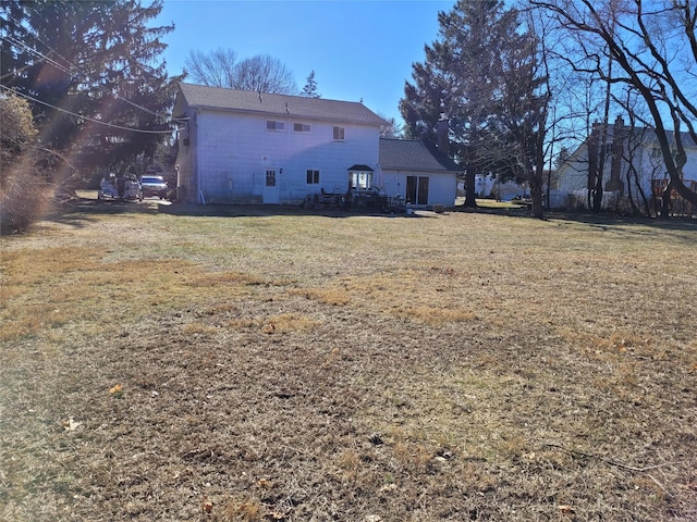 rear view of house featuring a lawn