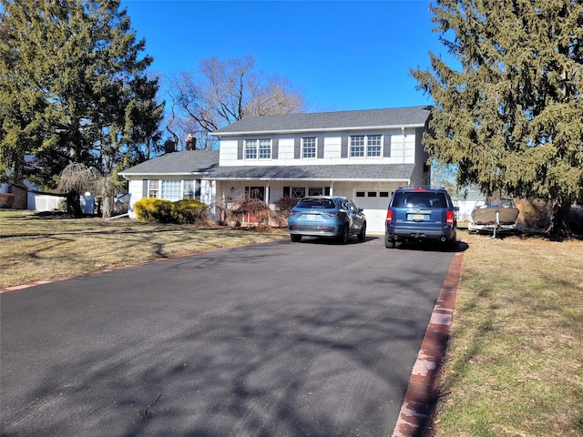 view of front of property with a garage and a front lawn