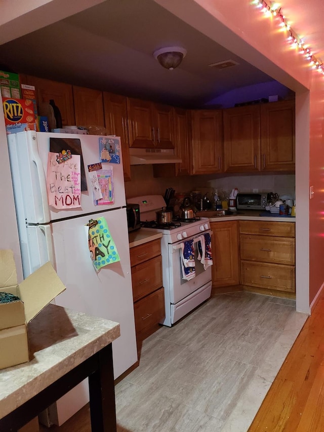 kitchen with light wood-type flooring and white appliances