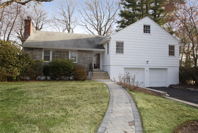 tri-level home with a garage and a front lawn