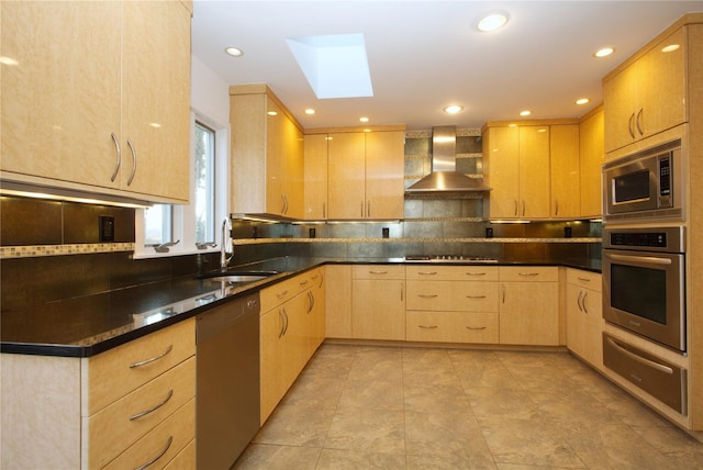 kitchen with appliances with stainless steel finishes, sink, light brown cabinetry, and wall chimney exhaust hood