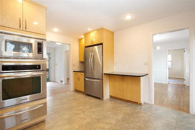 kitchen with stainless steel appliances and light brown cabinetry