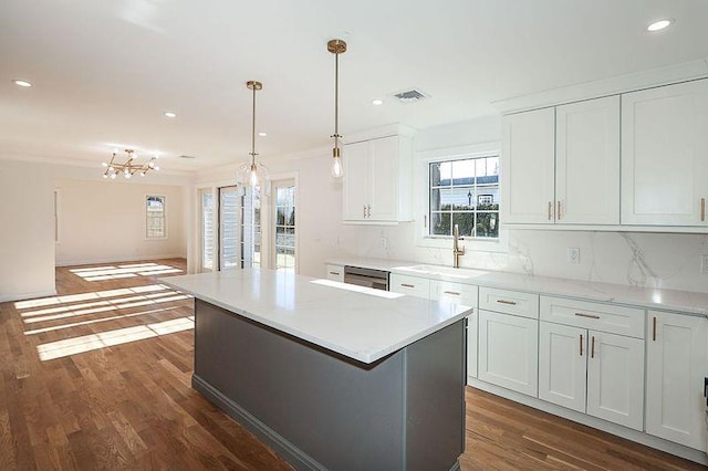 kitchen featuring white cabinetry, backsplash, decorative light fixtures, and dark wood-type flooring