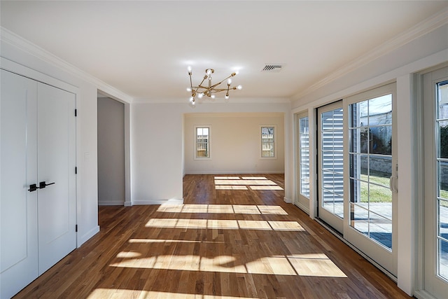 hall featuring an inviting chandelier, dark wood-type flooring, and ornamental molding