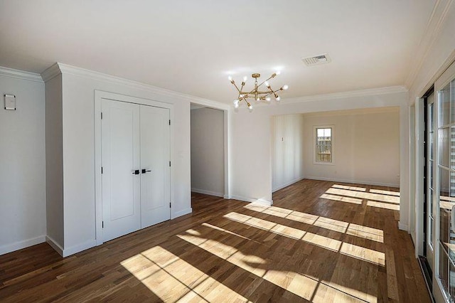 empty room with ornamental molding, dark wood-type flooring, and an inviting chandelier