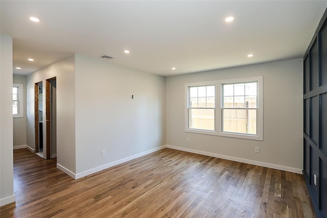 spare room featuring plenty of natural light and hardwood / wood-style floors