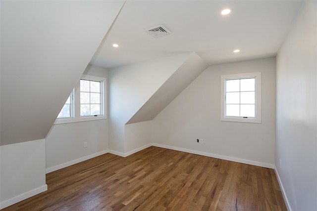 bonus room with dark wood-type flooring and vaulted ceiling